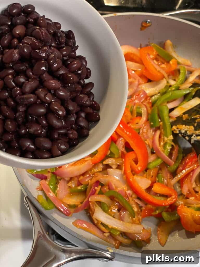 Sizzling Veggie Tacos 7 process of beans being poured into pan of veggies