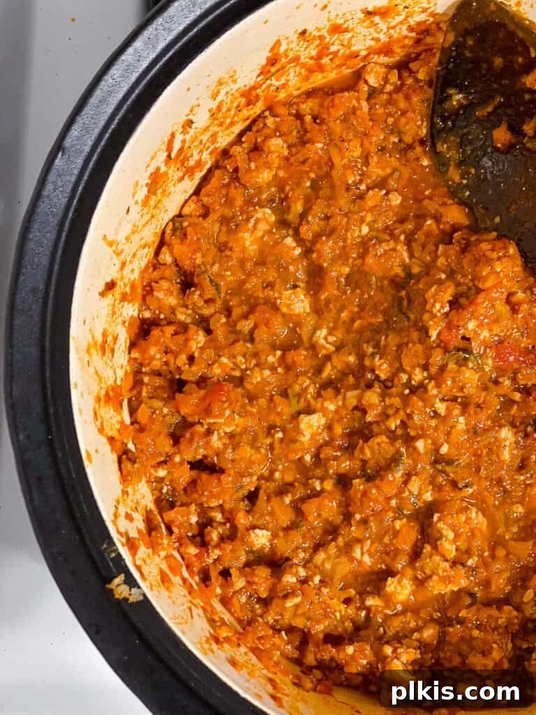 Hearty Vegan Ragu 15 Process shot of the Tofu Bolognese simmering gently in the pot, developing rich flavors and thickening.