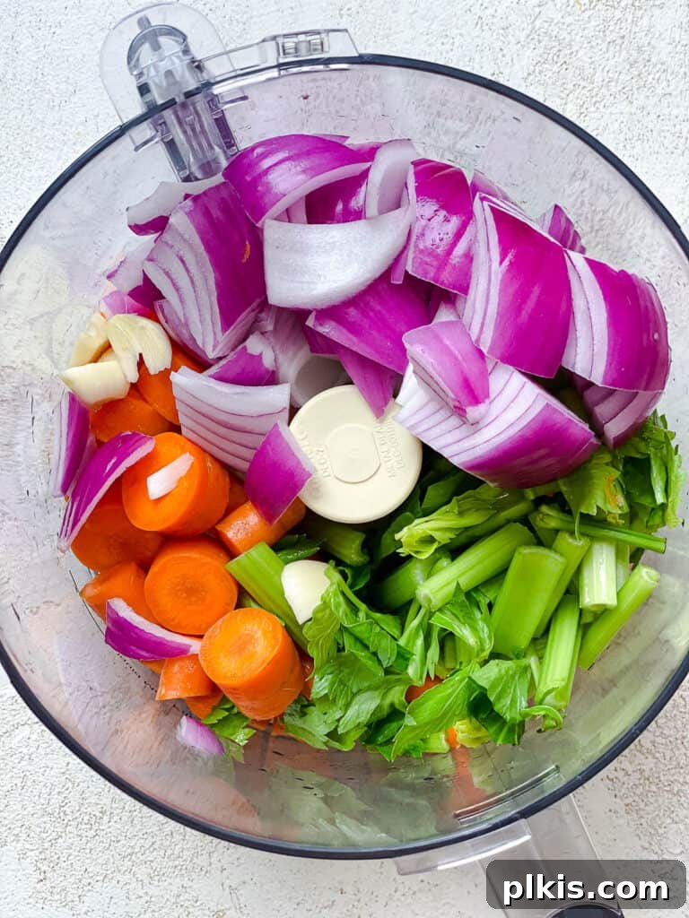 Hearty Vegan Ragu 4 Process shot showing a food processor with roughly chopped vegetables, ready to be pulsed for the bolognese base.