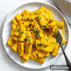completed and plated Easy Carrot Pasta Sauce against a white surface