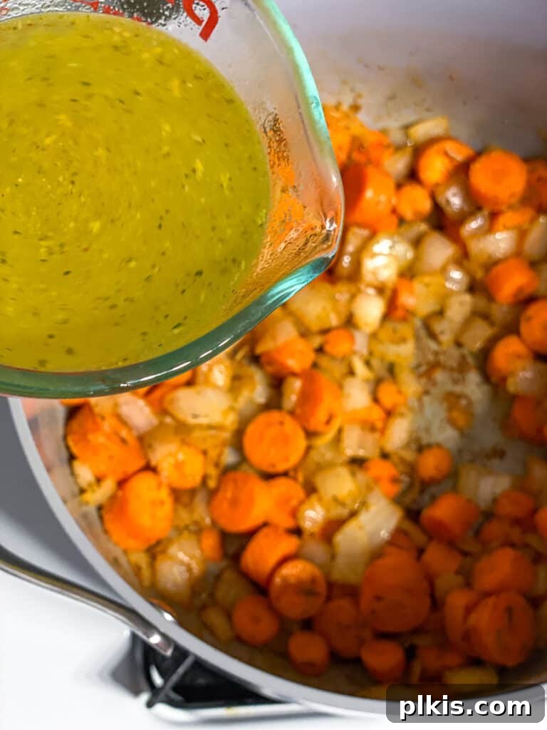 Simple Golden Carrot Sauce 8 process shot of adding veggie broth to pan
