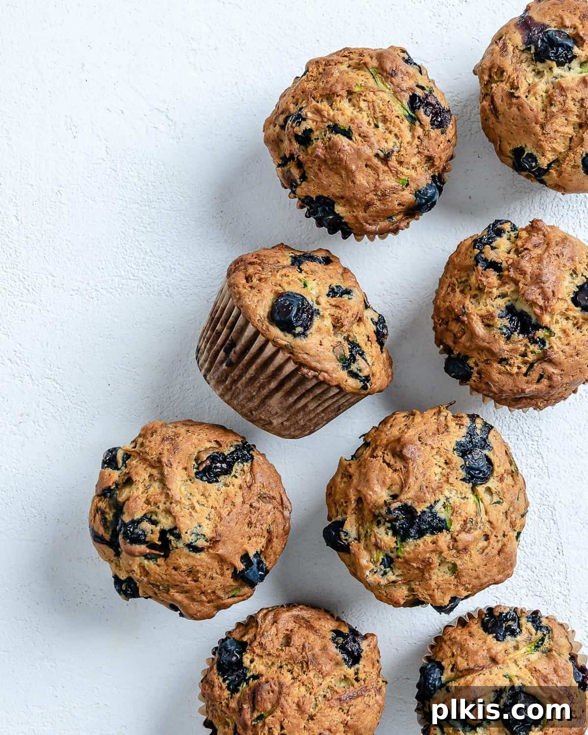 Garden-Fresh Vegan Blueberry Zucchini Muffins 2 Completed Blueberry Zucchini Muffins against a white background.