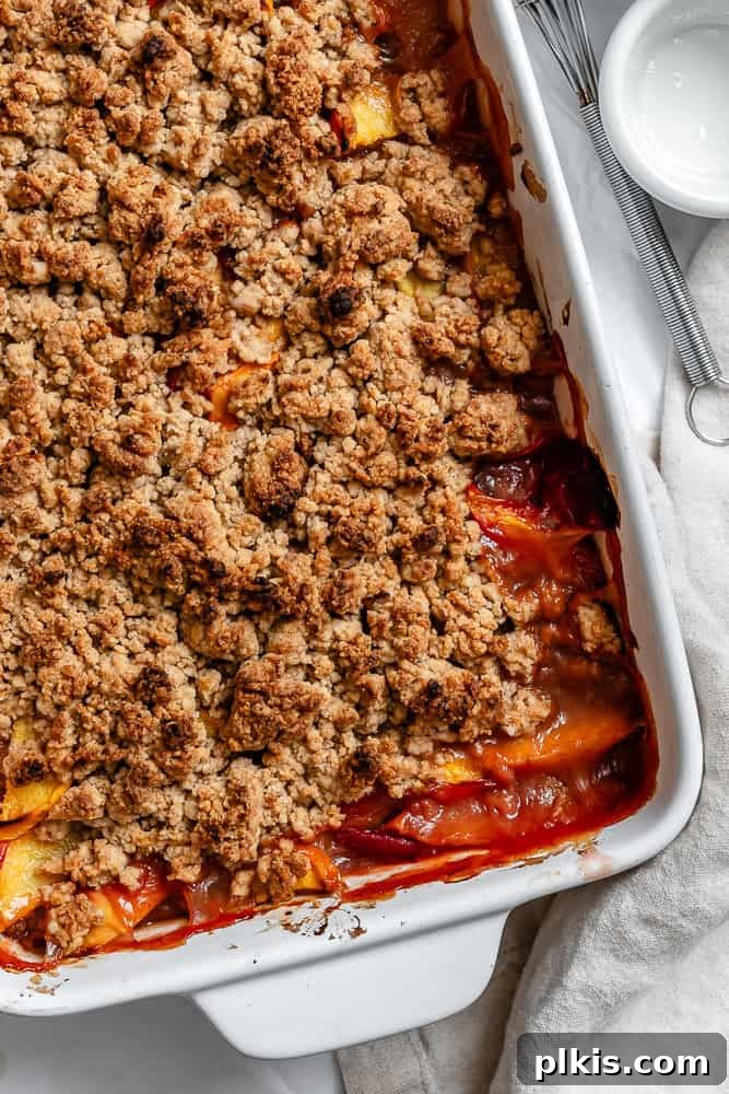 Effortless Vegan Peach Cobbler 2 A beautifully baked Easy Vegan Peach Cobbler in a baking dish, golden brown and bubbling, ready to be served.