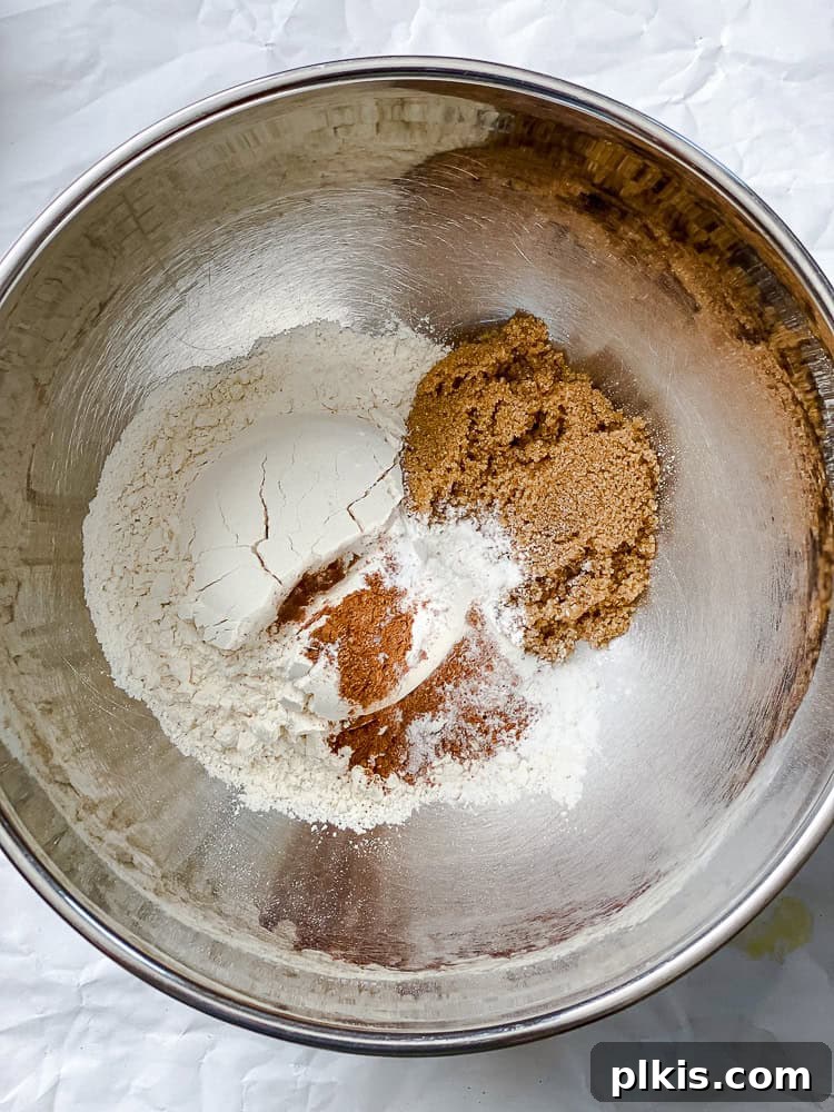 Effortless Vegan Peach Cobbler 7 Process shot showing dry ingredients for the cobbler topping being mixed in a bowl.