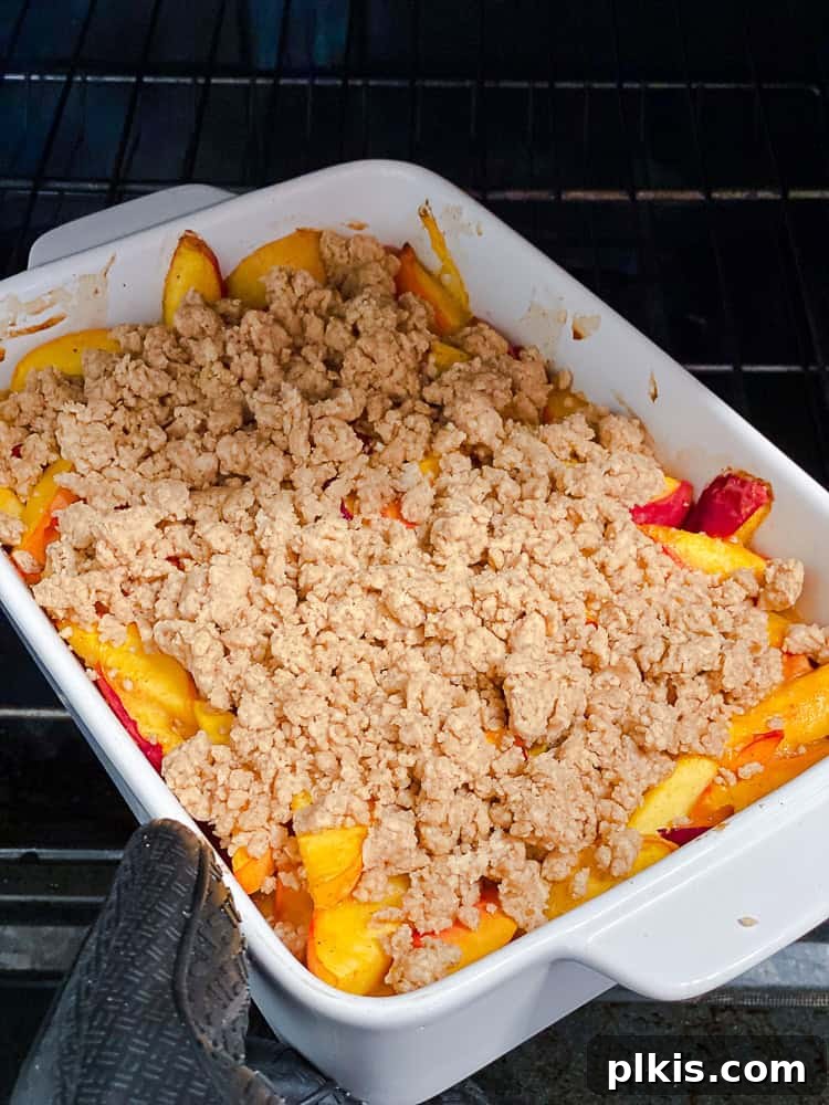 Effortless Vegan Peach Cobbler 9 Process shot showing dollops of biscuit dough placed over the baked peaches in the baking dish.