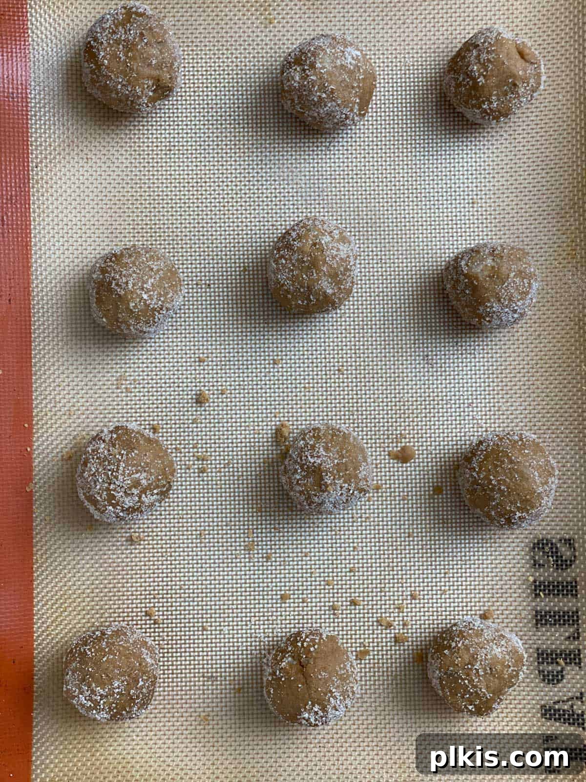 Bold Triple Ginger Vegan Snaps 15 Several unbaked Triple Ginger Vegan Gingersnaps, rolled and sugar-coated, neatly arranged on a baking tray before entering the oven.