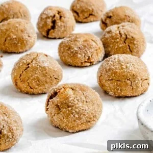 Several completed Triple Ginger Vegan Ginger Cookies [Gingersnaps] on a white surface.