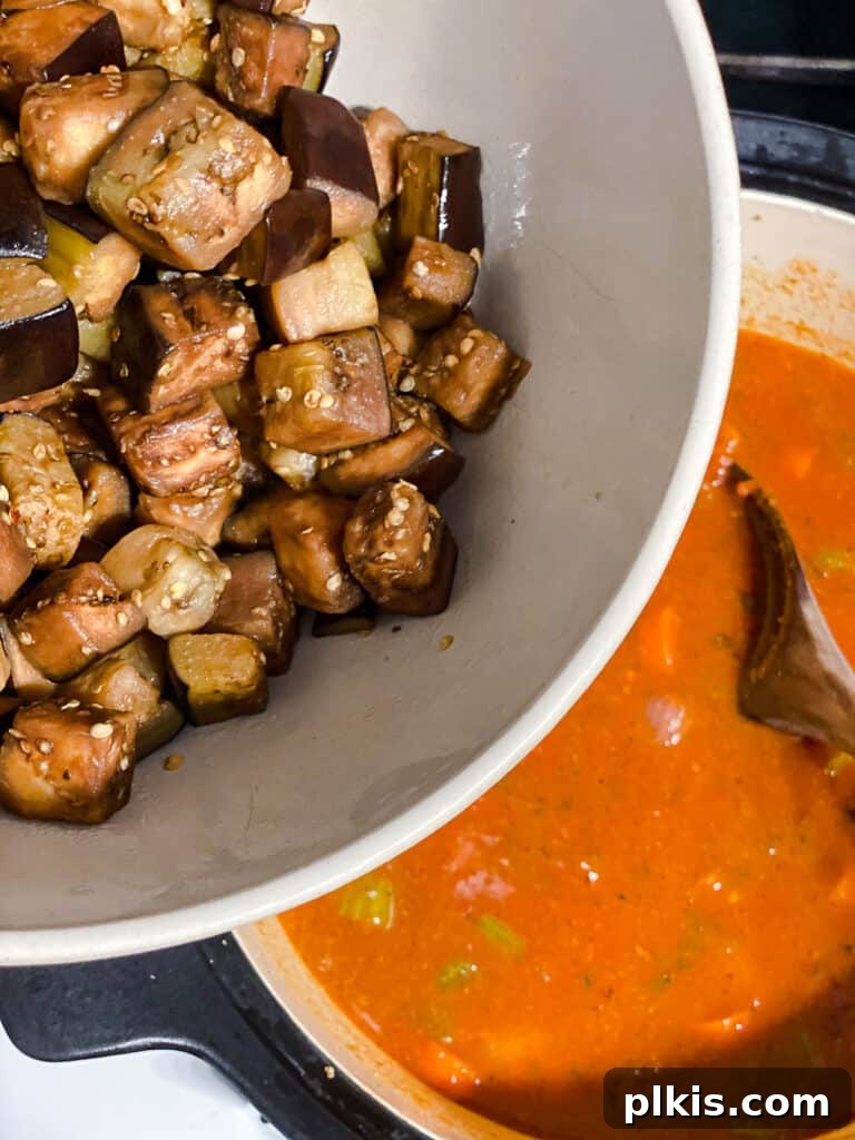 Hearty Eggplant, Tomato, and Chickpea Stew 13 Cooked eggplant being returned to the simmering stew.