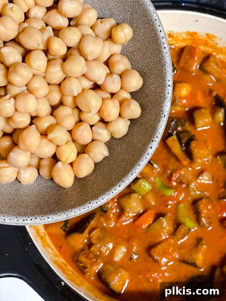 Hearty Eggplant, Tomato, and Chickpea Stew 14 Chickpeas being added to the stew for simmering.