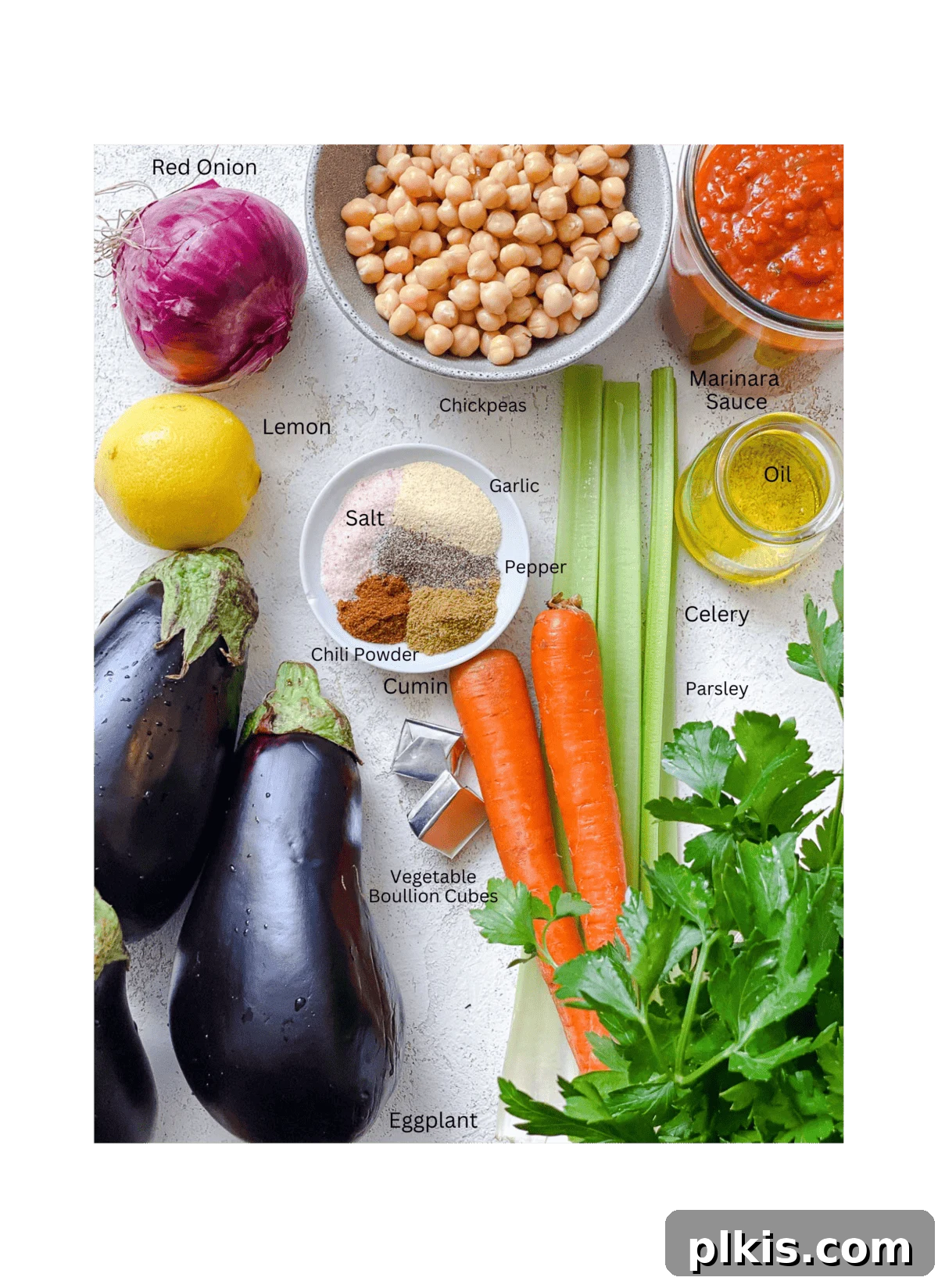 Hearty Eggplant, Tomato, and Chickpea Stew 3 A selection of fresh ingredients including eggplant, chickpeas, carrots, celery, onion, garlic, tomato sauce, and spices, laid out on a white surface for making Eggplant Stew.
