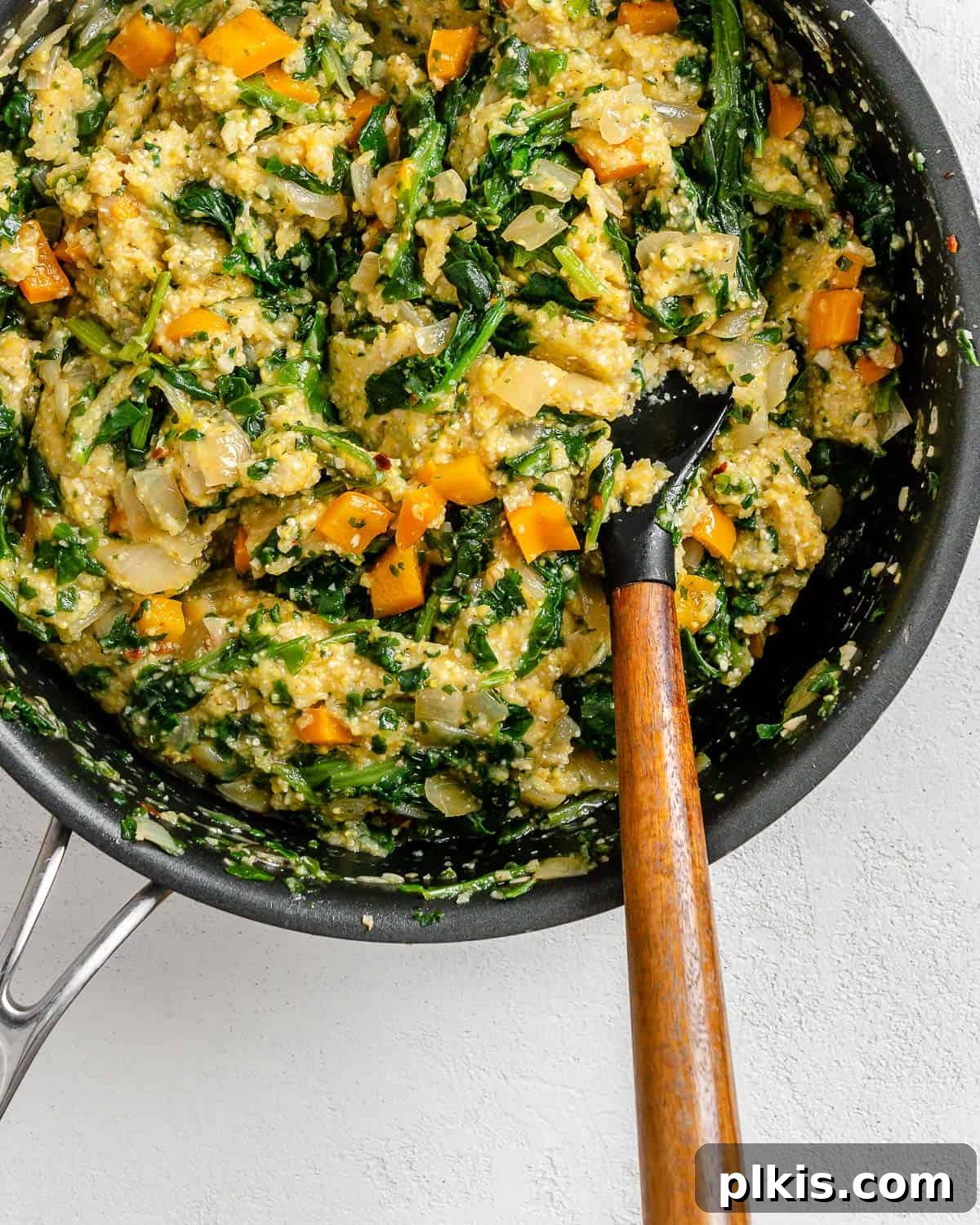 Golden Polenta Spinach Bake 17 A process shot of mixing the polenta pie ingredients vigorously in a pan until the spinach and vegetables are evenly incorporated into the polenta.