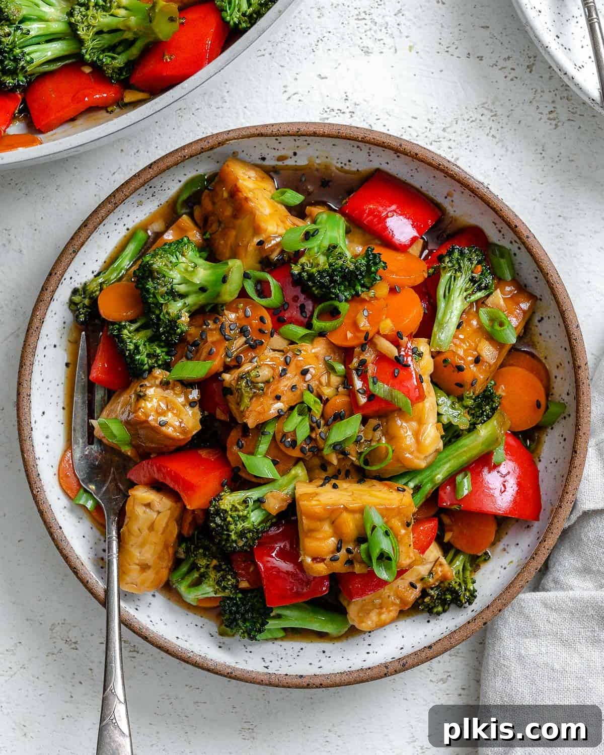 Simple Sizzling Tempeh 2 completed Easy Tempeh Stir-Fry plated on a white plate against a white surface