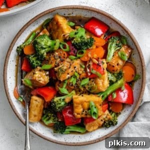 completed Easy Tempeh Stir-Fry plated on a white plate against a white surface