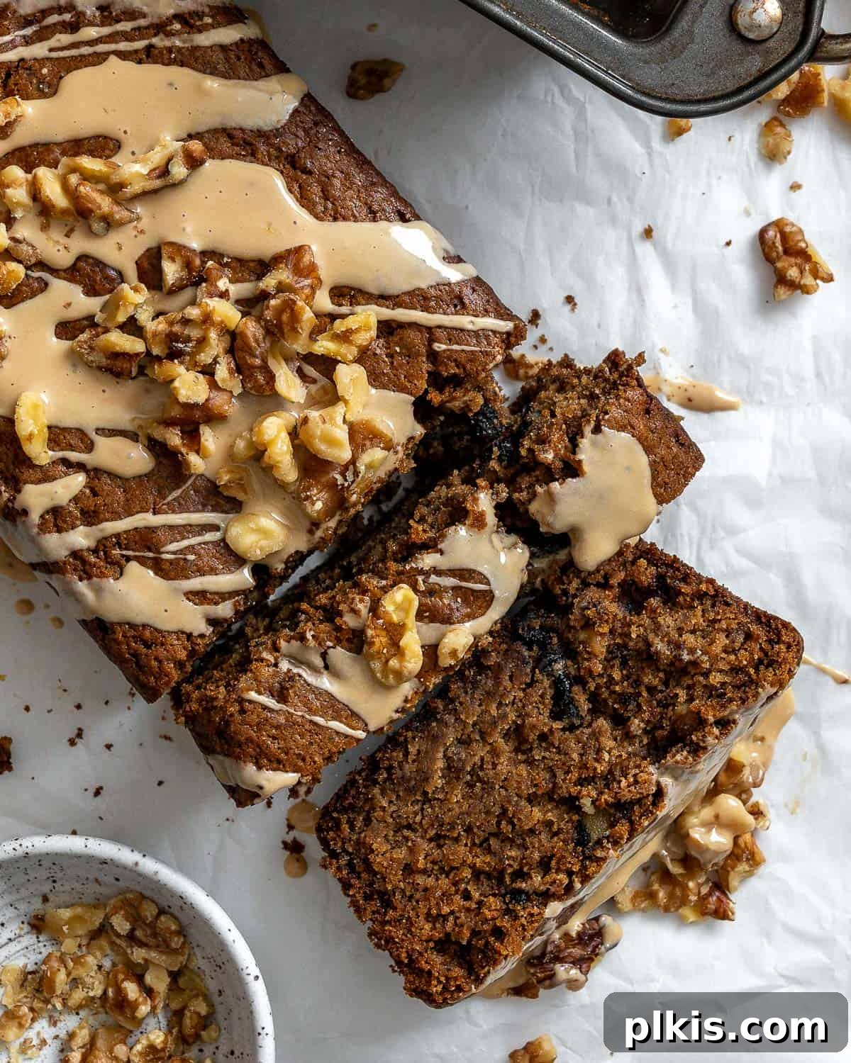 Moist Coffee Walnut Loaf 2 Deliciously moist vegan coffee and walnut loaf cake with a sweet coffee glaze, ready to be served on a white surface.