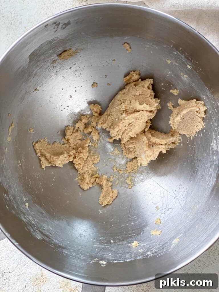 Moist Coffee Walnut Loaf 5 A process shot showing vegan butter and brown sugar being creamed together in a large mixing bowl with an electric mixer, achieving a light and fluffy consistency.