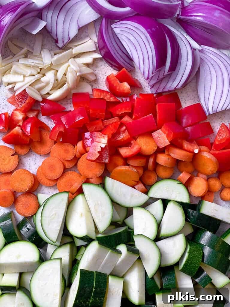 Speedy Zucchini Stir-Fry 4 Assortment of freshly sliced carrots, bell peppers, onions, and zucchini on a cutting board, ready for stir-frying.