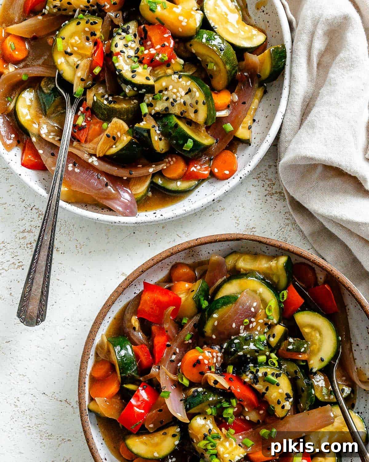 Speedy Zucchini Stir-Fry 9 Two bowls of freshly prepared Easy Zucchini Stir Fry, garnished with sesame seeds and green onions, showcasing a vibrant and appealing meal.
