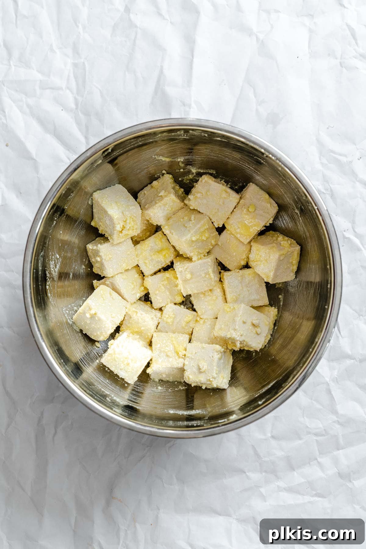 Golden Crispy Tofu with Rich Peanut Sauce 5 Process shot showing tofu with seasoning mixed together in a bowl.