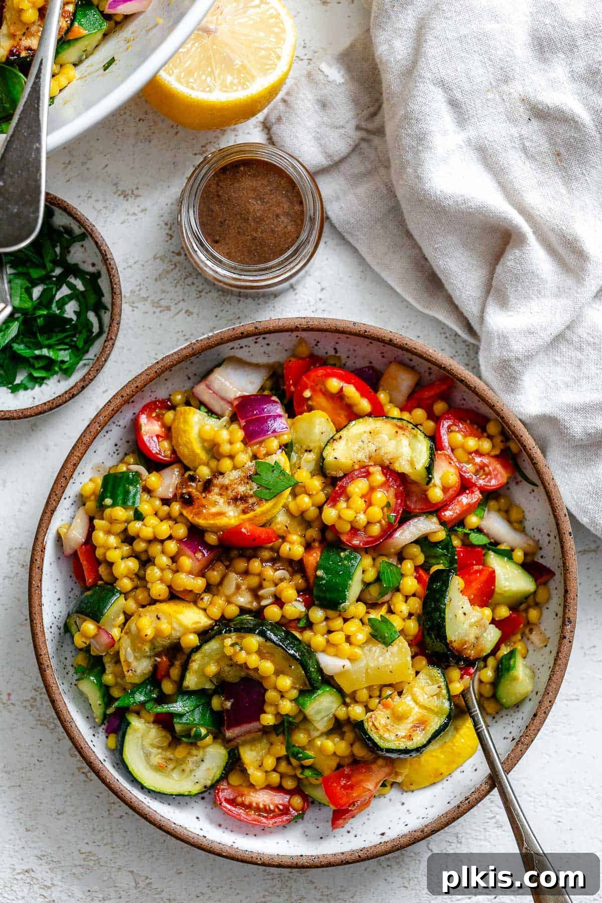 Vibrant Garden Couscous Salad 2 Completed Couscous Salad with Roasted Vegetables in a large white bowl, garnished with fresh parsley.