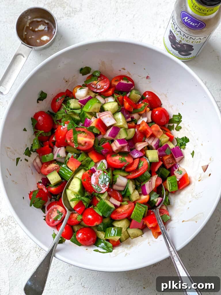 Vibrant Garden Couscous Salad 12 Mixing fresh vegetables with balsamic vinaigrette in a bowl.