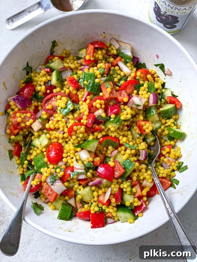 Vibrant Garden Couscous Salad 15 Gently mixing couscous with fresh vegetables and dressing in a large bowl.