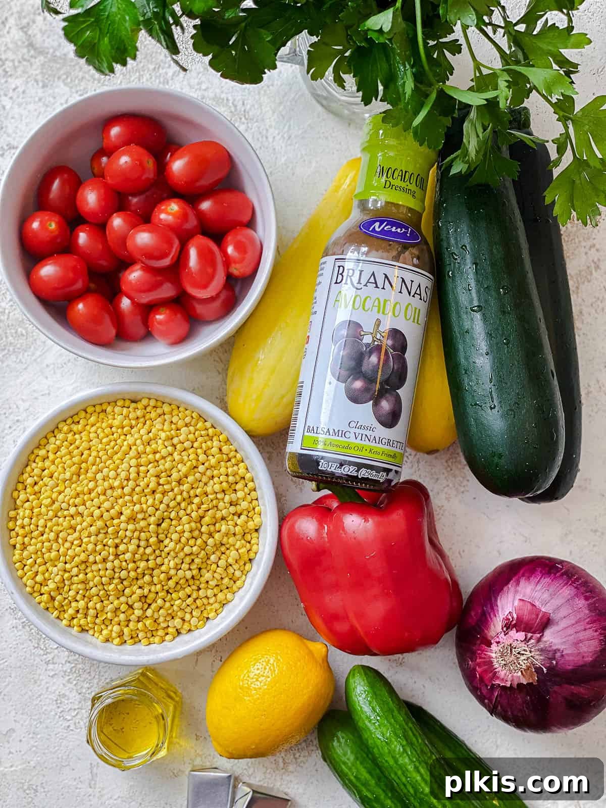 Vibrant Garden Couscous Salad 3 Assorted fresh vegetables and couscous ingredients laid out on a white surface.