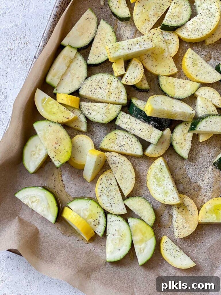 Vibrant Garden Couscous Salad 8 Sliced zucchini and summer squash on a baking tray, seasoned and ready for roasting.