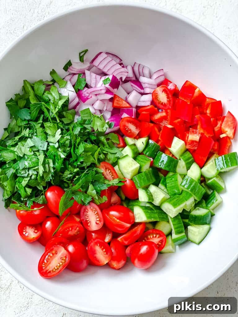 Vibrant Garden Couscous Salad 10 Sliced fresh vegetables including bell pepper, cucumber, and cherry tomatoes in a bowl.