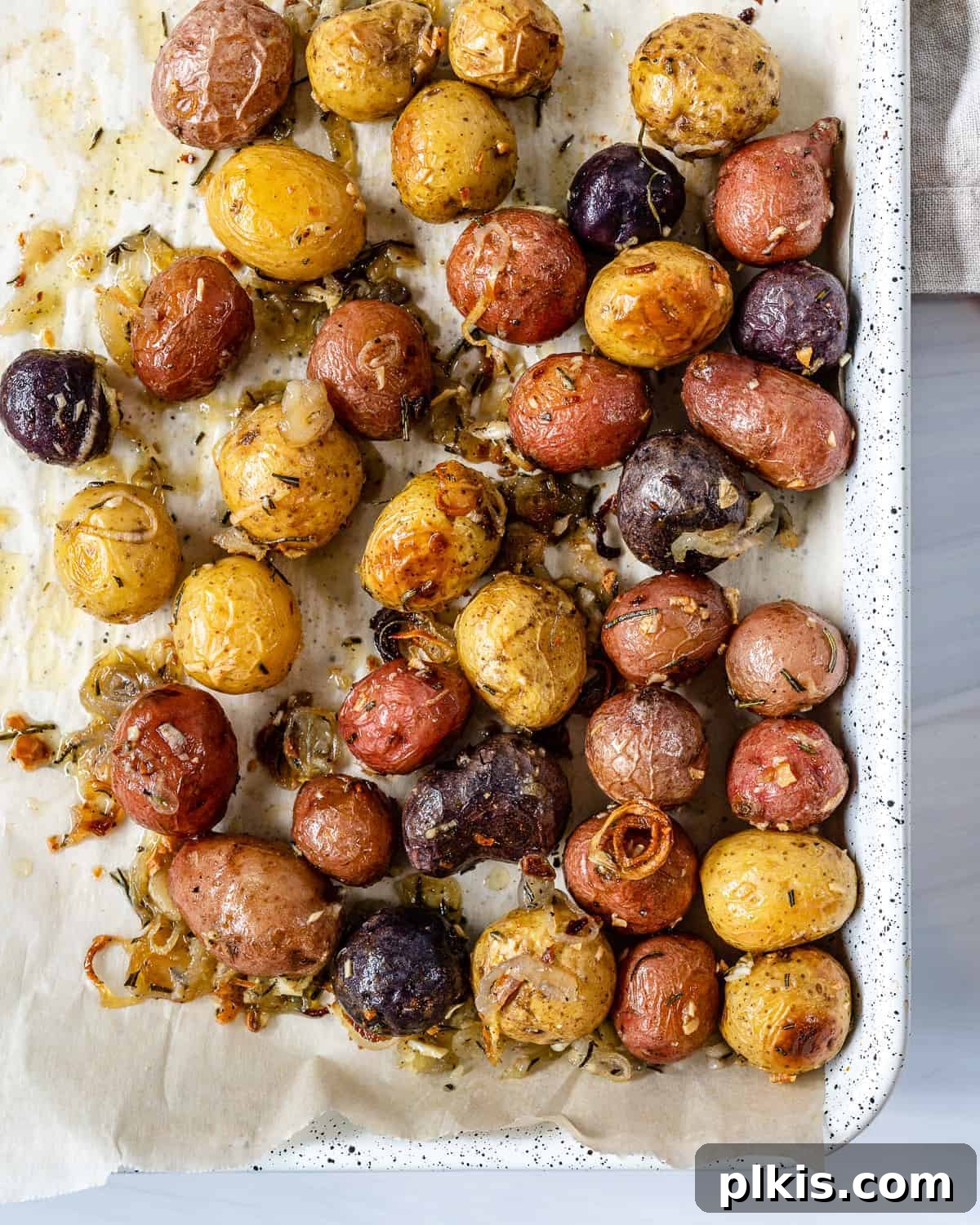 30 Effortless Plant-Based Potato Creations 11 completed Roasted Rosemary Potatoes in a white tray
