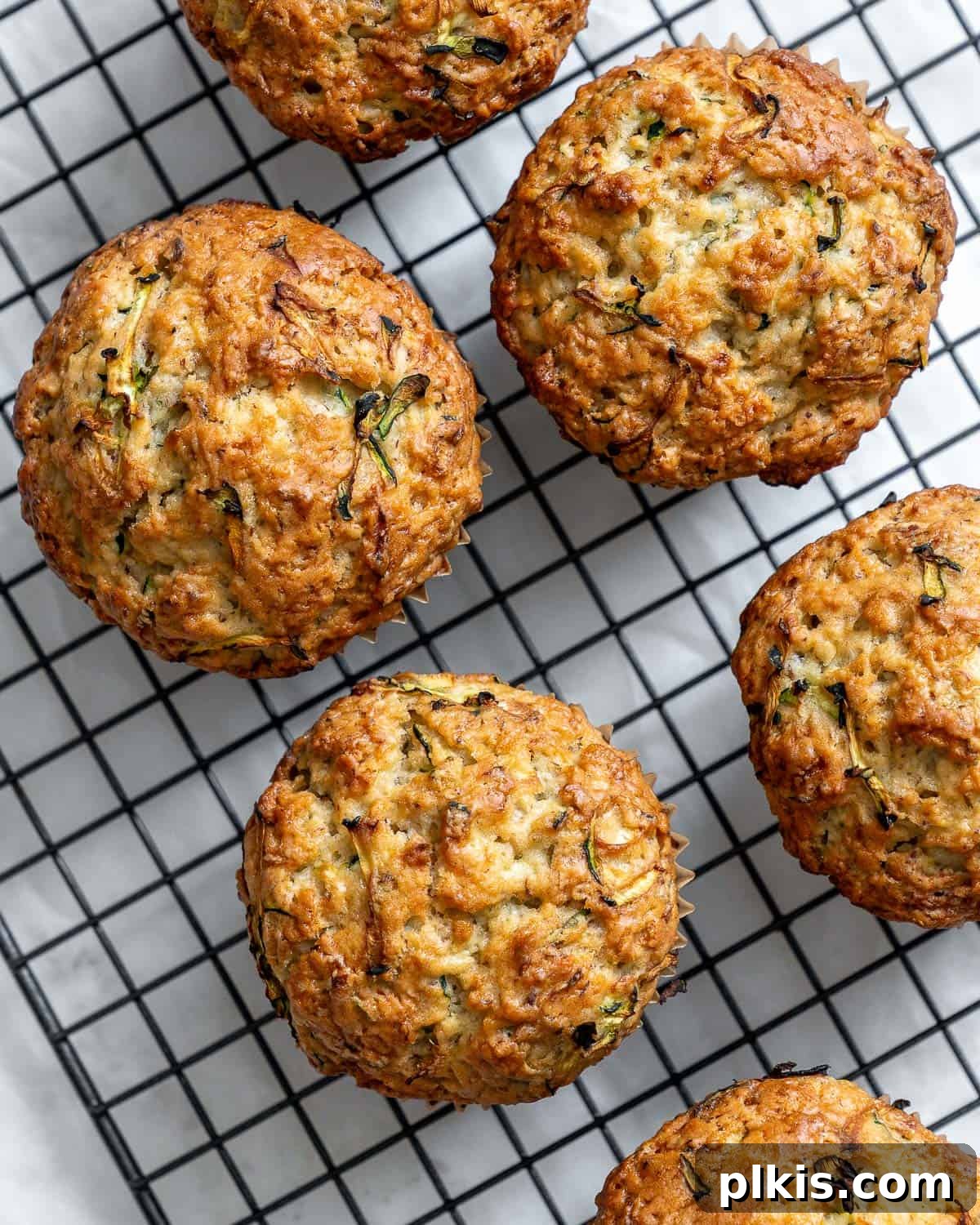Wholesome Vegan Zucchini Muffins 2 Delicious and easy vegan zucchini muffins cooling on a wire rack, ready to be enjoyed.