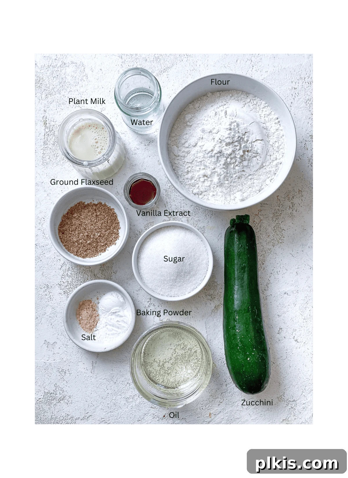 Wholesome Vegan Zucchini Muffins 3 All ingredients for easy vegan zucchini muffins meticulously measured out on a white surface, showcasing the simplicity of the recipe.
