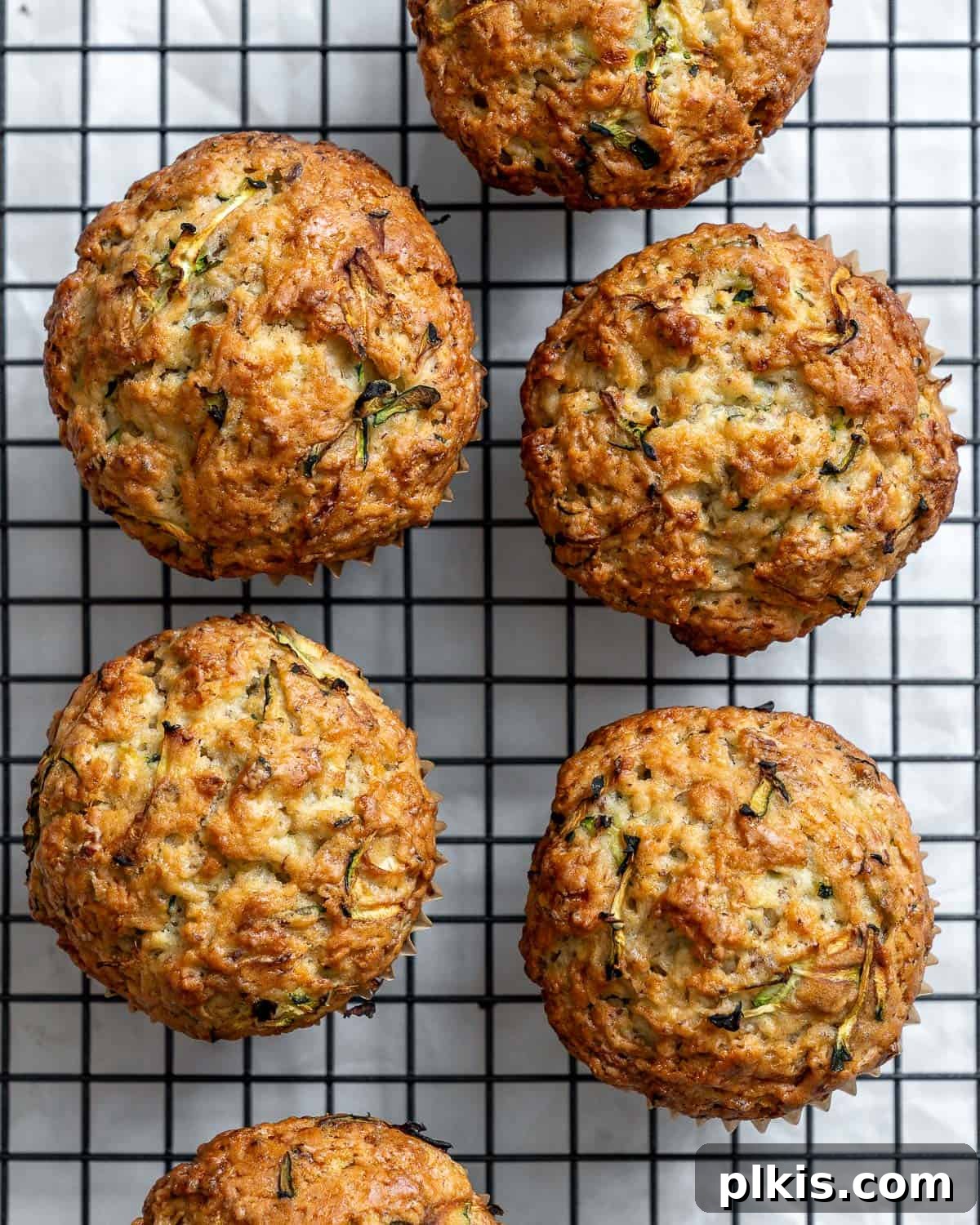 Wholesome Vegan Zucchini Muffins 9 A close-up of beautifully baked easy vegan zucchini muffins cooling on a rack, showcasing their golden tops and tender texture.