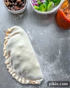 one un-baked calzone on a gray surface