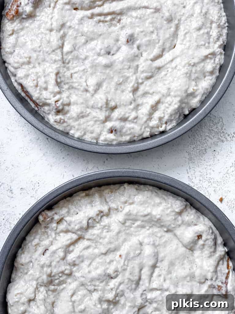 Decadent Vegan Biscoff Dream 16 two cake pans with cake batter against a white surface, ready for Biscoff swirl
