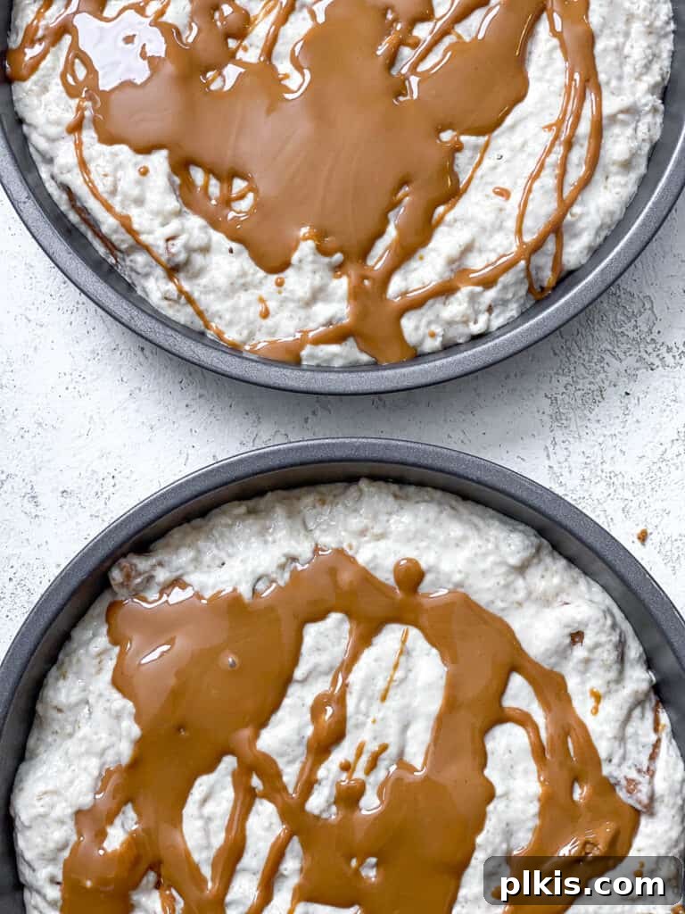 Decadent Vegan Biscoff Dream 17 process shot of adding cookie butter to cake pans, drizzling melted Biscoff