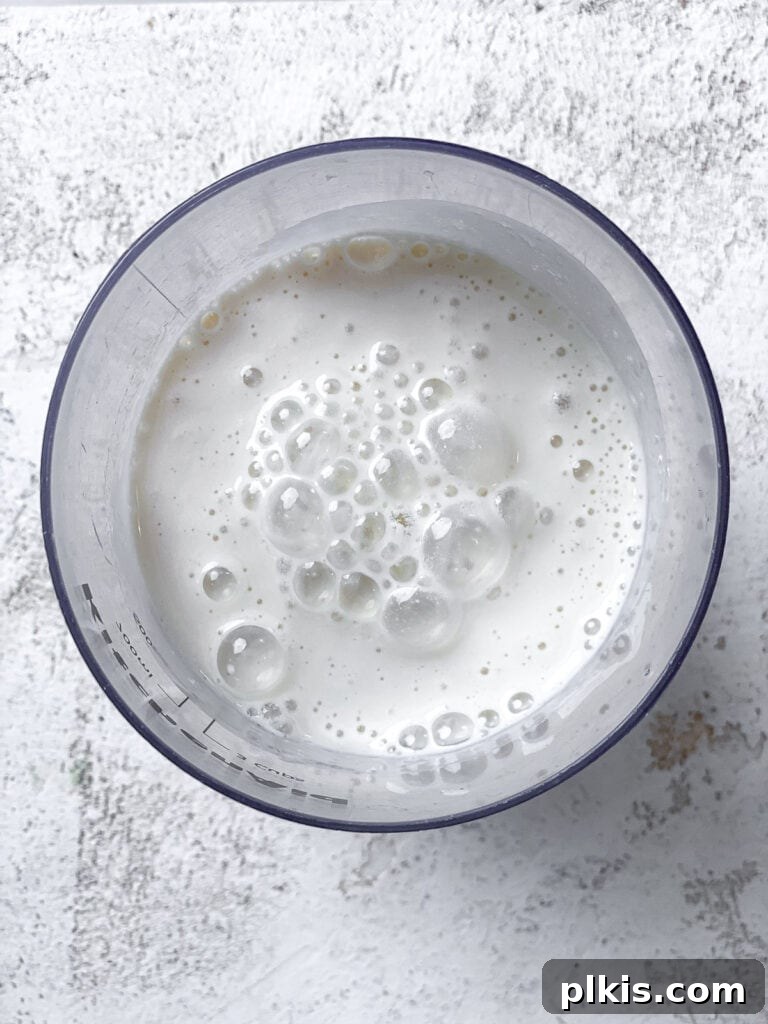 Decadent Vegan Biscoff Dream 5 mixed plant based milk and apple cider vinegar in a glass, showing the curdled buttermilk