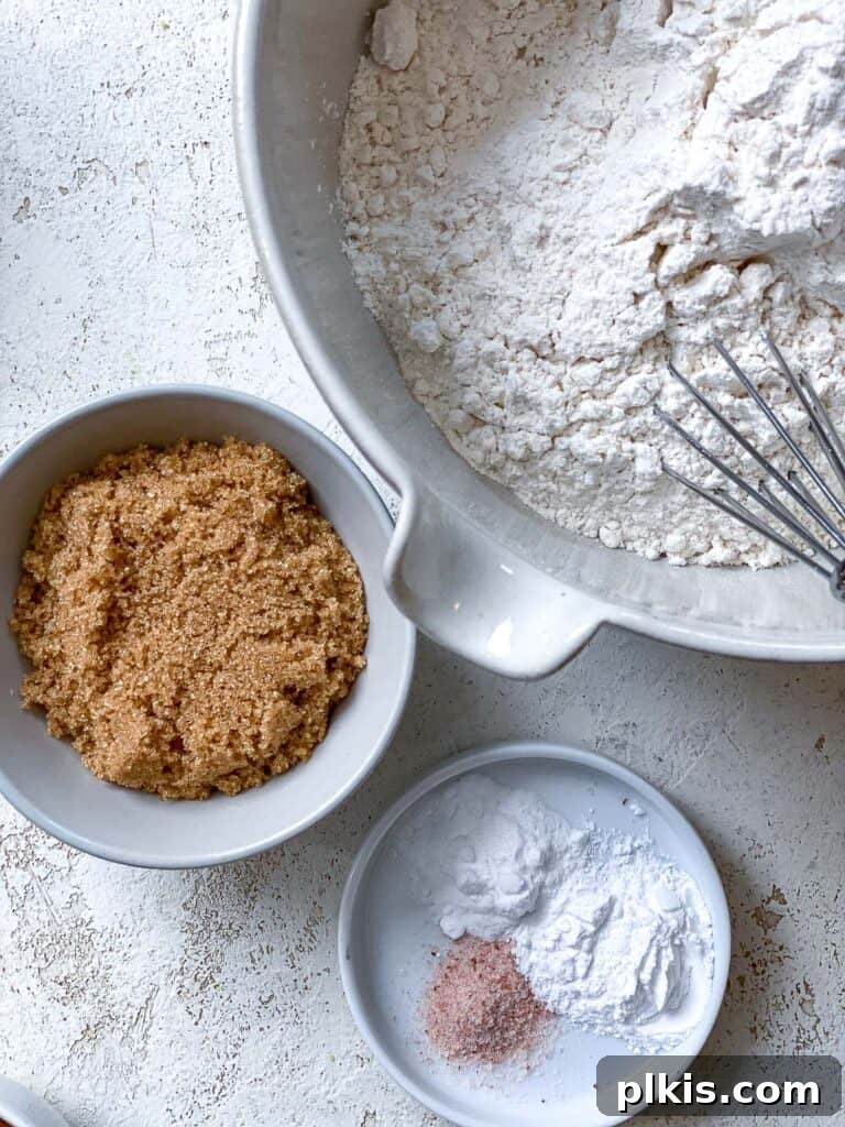 Decadent Vegan Biscoff Dream 6 ingredients for Vegan Biscoff Cake against a white surface, showing dry ingredients in a bowl