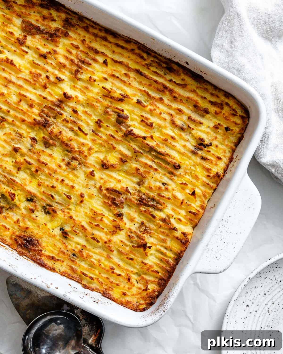 Wholesome Lentil Shepherd's Comfort 21 A golden-brown vegan lentil shepherd's pie, freshly baked in a casserole dish, with steam gently rising, showcasing its hearty appeal.