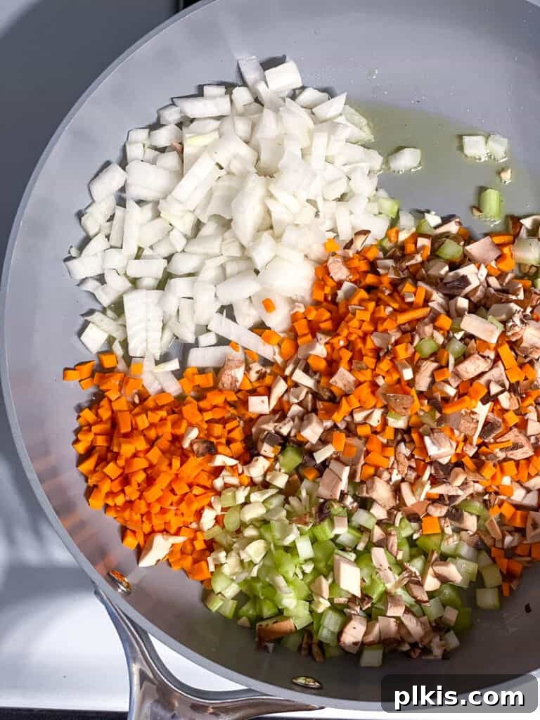 Wholesome Lentil Shepherd's Comfort 9 Mixed vegetables sizzling in a hot pan, beginning to soften and release their flavors.