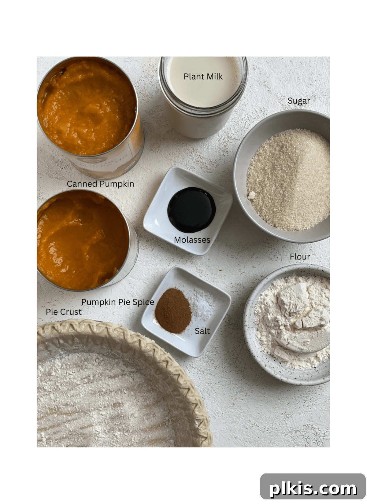 Effortless Vegan Pumpkin Perfection 3 Precisely measured ingredients for a delicious Easy Vegan Pumpkin Pie, laid out on a clean white surface, showcasing canned pumpkin, plant-based milk, sugar, flour, vanilla, salt, and pumpkin pie spice.