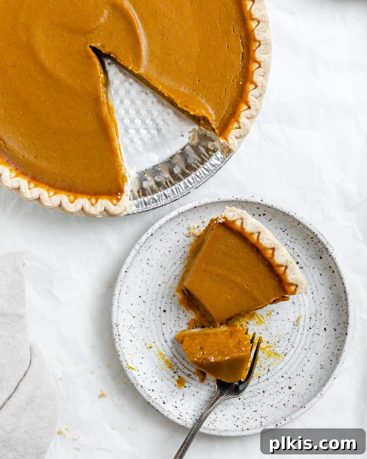 Effortless Vegan Pumpkin Perfection 7 A delectable slice of Easy Vegan Pumpkin Pie served alongside the whole pie, ready to be enjoyed as a perfect plant-based dessert.