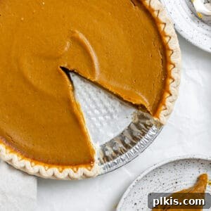 Effortless Vegan Pumpkin Perfection 8 Completed Easy Vegan Pumpkin Pie with a slice plated, ready for serving.