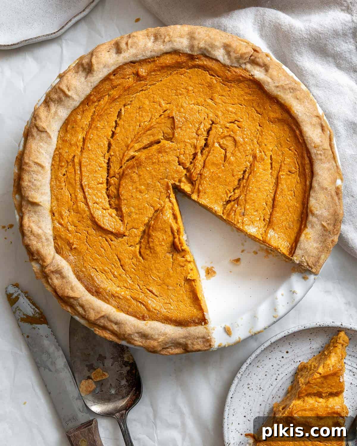 Creamy Vegan Sweet Potato Dream 2 A perfectly baked, golden-brown Vegan Sweet Potato Pie, sliced and ready to serve on a white background, highlighting its creamy texture.