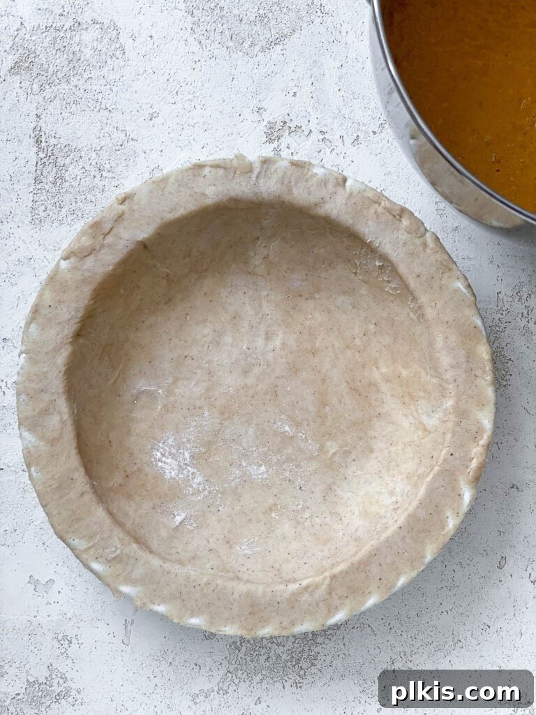 Creamy Vegan Sweet Potato Dream 13 An empty, unbaked pie crust resting on a white surface, ready for filling.