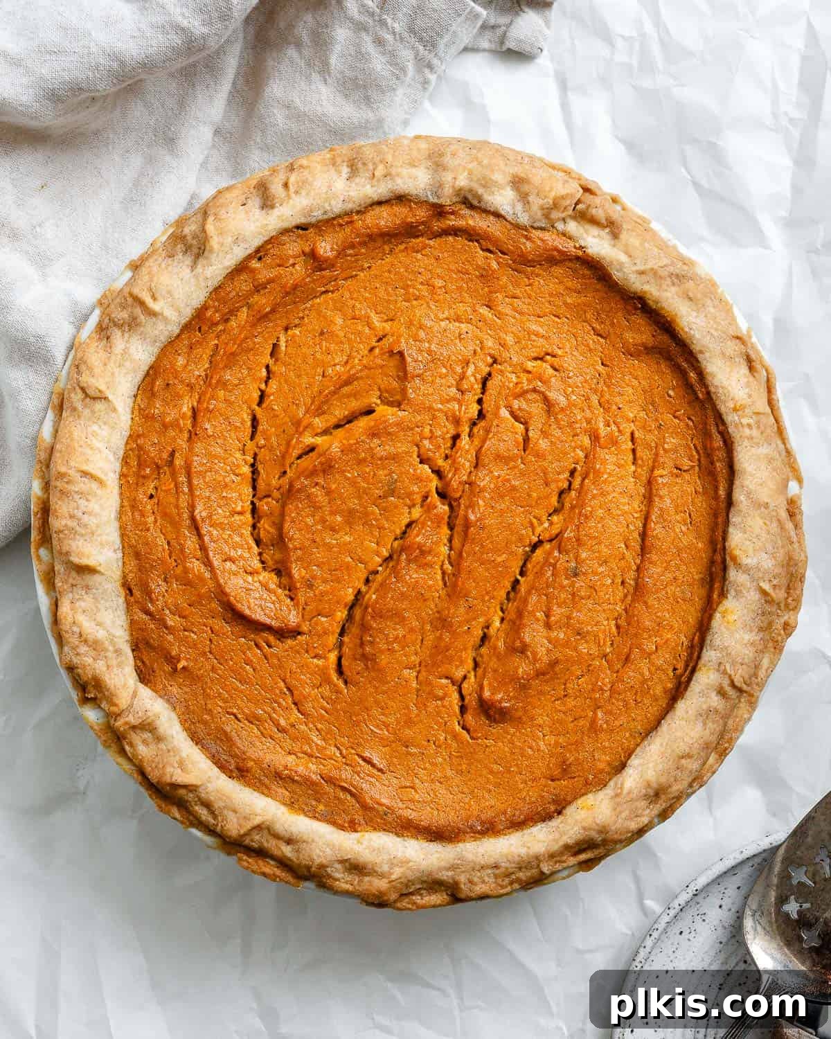 Creamy Vegan Sweet Potato Dream 16 A beautifully finished Vegan Sweet Potato Pie, perfectly golden and ready to be served, resting on a white surface.