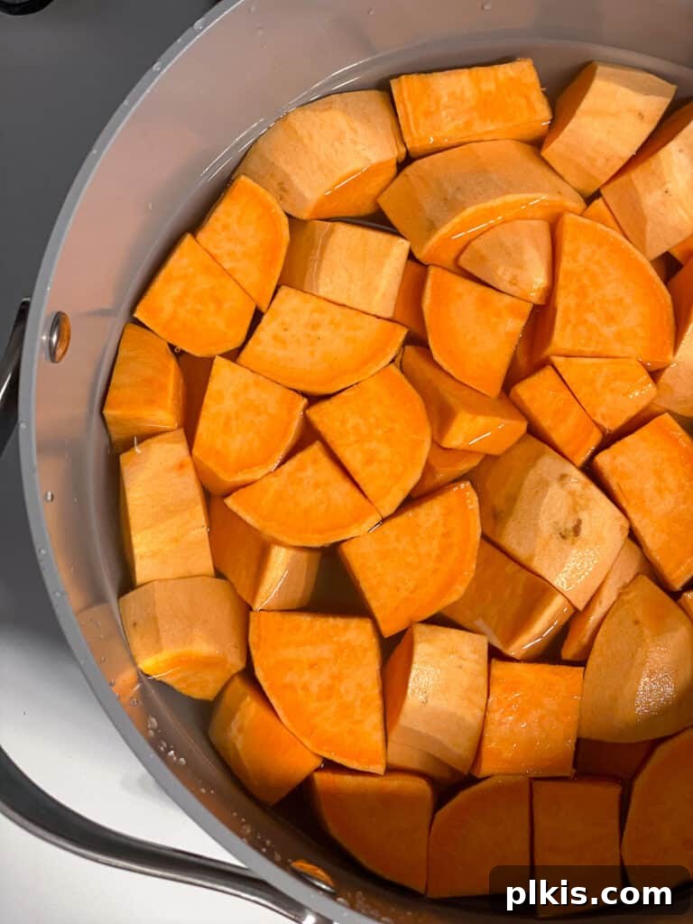 Creamy Vegan Sweet Potato Dream 5 Cubed sweet potatoes in a large cooking pot, submerged in water, ready to be boiled.