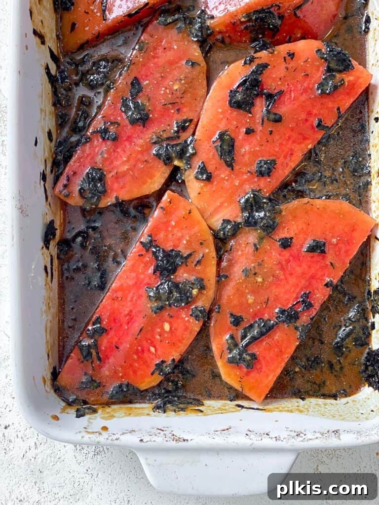 Watermelon Tuna: Sashimi and Steaks 7 Process shot illustrating marinated watermelon slices on a baking dish, flipped to ensure even coating and ready for baking. The vibrant red melon is richly covered in the dark marinade.
