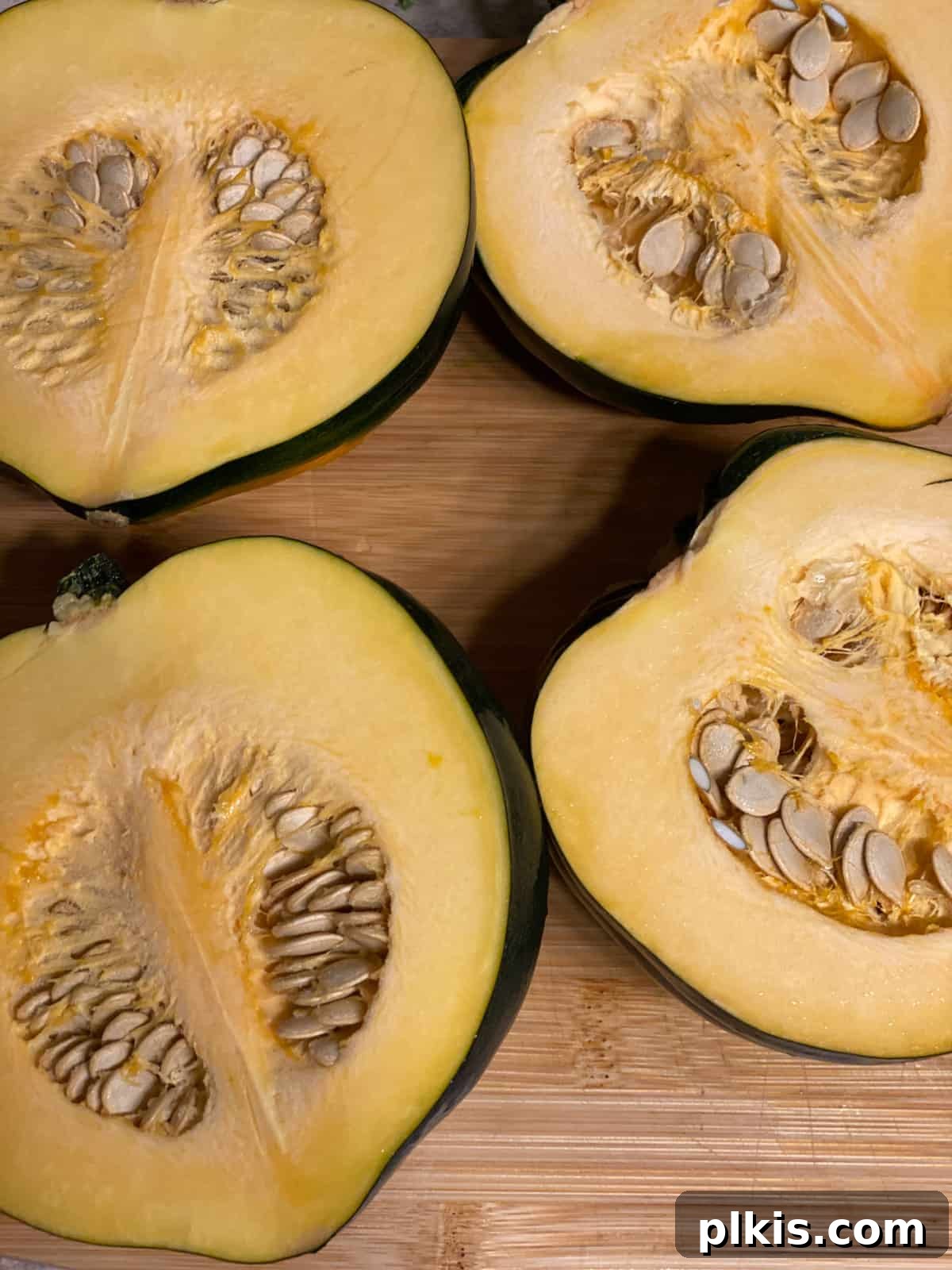 Hearty Vegan Quinoa Stuffed Acorn Squash 4 rawacorn squash sliced in half on a cutting board
