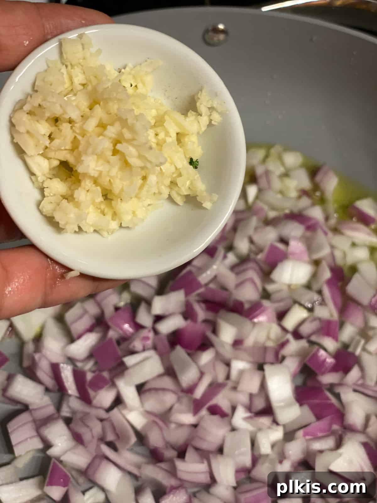 Hearty Vegan Quinoa Stuffed Acorn Squash 7 process shot of garlic being added to pan