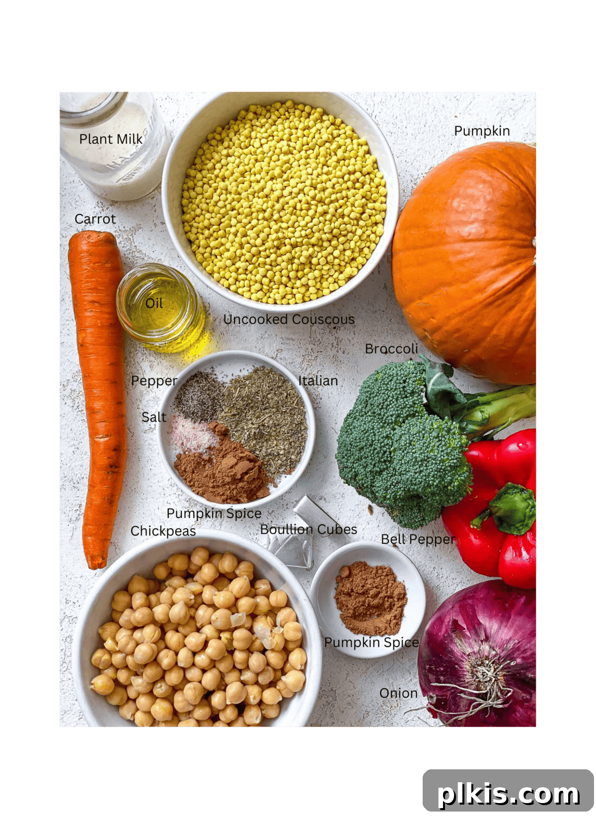 Harvest Roasted Pumpkin Couscous Salad 3 Various fresh ingredients for Roasted Pumpkin Couscous Salad laid out on a white surface, including pumpkin, spices, and vegetables.